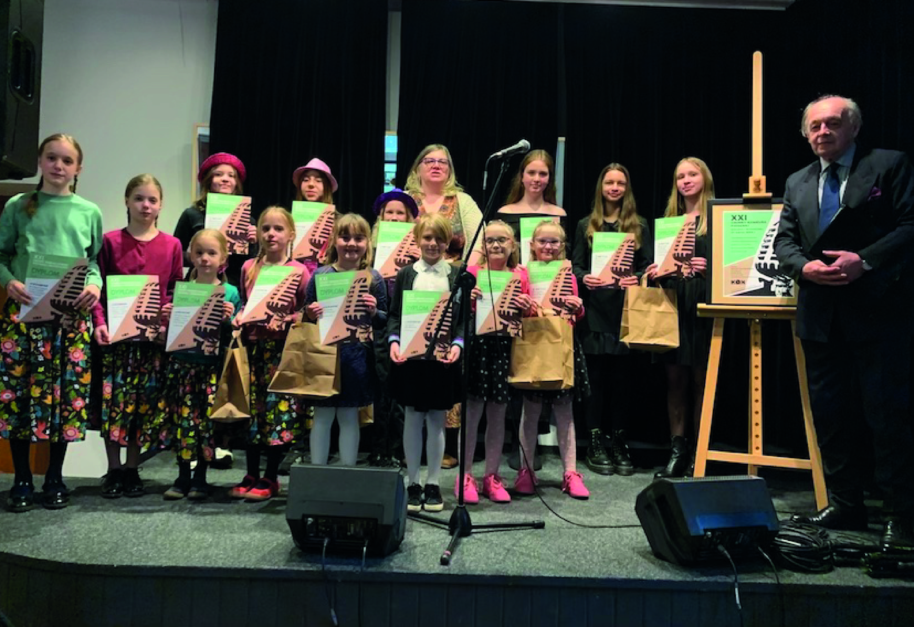 Nagrodzone dzieci wraz z członkami jury stojący na scenie